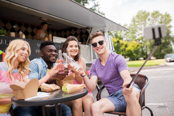 happy young friends taking selfie at food truck