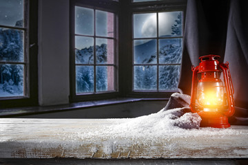 Wooden table of free space for your decoration. Background of window and view of mountains and moon on the sky with few stars. Santa claus home interior. 