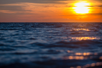 Obraz premium orange sun sets on the horizon of the sea