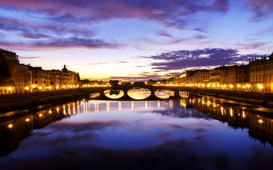Naklejka premium Late sunset time in Florence with street lights turned on and spectacular clouds over city and river.