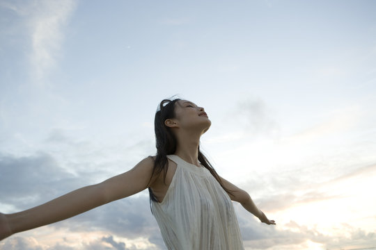 Woman daydreaming under sky