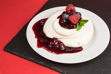 homemade pavlova meringue cake with raspberries and blueberries