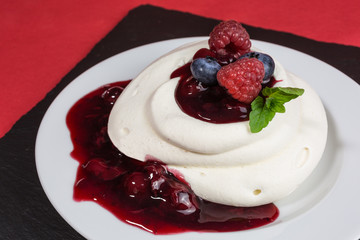 homemade pavlova meringue cake with raspberries and blueberries