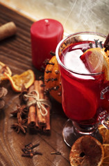 Glass of christmas hot mulled wine on wooden table with species and oranges against wooden table.Copy space
