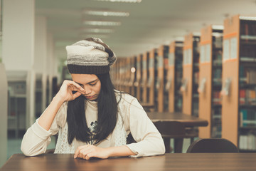 Asian sad girl in the library vintage style,thai woman stress from love,heartbreak concept,dark tone