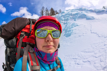 portrait female mountaineer with backpack, helmet and harness with climbing in mountain