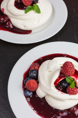 homemade pavlova meringue cake with raspberries and blueberries