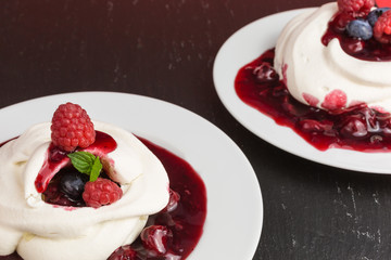 homemade pavlova meringue cake with raspberries and blueberries