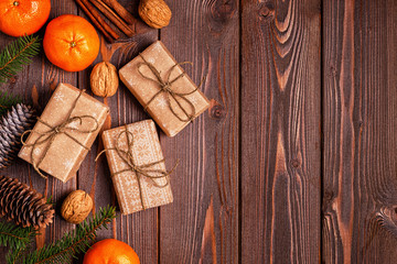 Christmas composition with tangerines, gift boxes, cones on a dark wooden background.