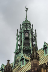Fototapeta na wymiar Sydney, Australia - March 25, 2017: Closeup of historic green bronze decorated spire on top of Maclaurin Hall at University of Sydney under heavy sky. Roof structure.