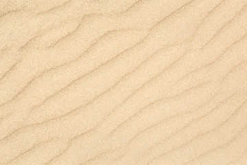 Fototapeta na wymiar Sand waves texture with diagonal pattern. Sandy beach for background. Top view
