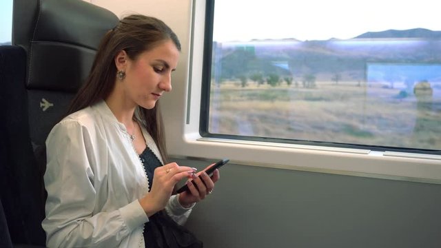 A young lady using a smartphone in the train. Medium shot.
