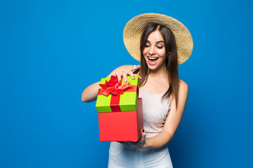 Portrait of an excited cute girl holding opened present box isolated over blue background