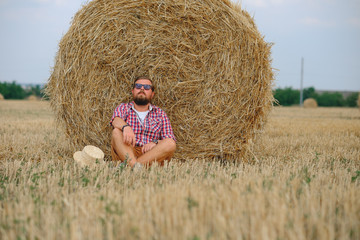 Naklejka na ściany i meble man resting after hay in haystacks