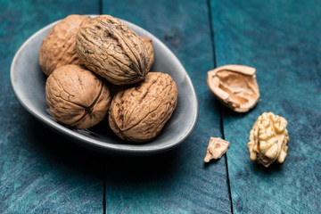 Walnüsse auf petrolfarbenen Holz in Schale