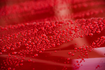 Wassertropfen auf einer roten Motorhaube