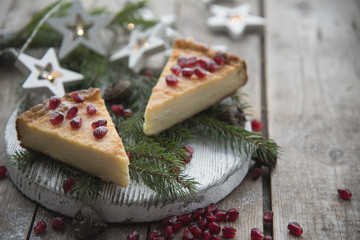 Cheesecake with pomegranate seeds, Christmas tree branches and Christmas decorations