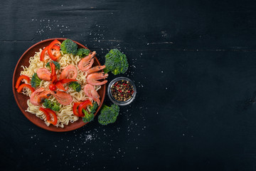 Asian food with seafood and vegetables. Shrimp, broccoli, paprika, spices. Top view. Free space for text.