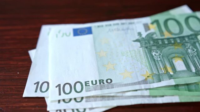 A pile of hundred euro banknotes on a table. Close-up shot
