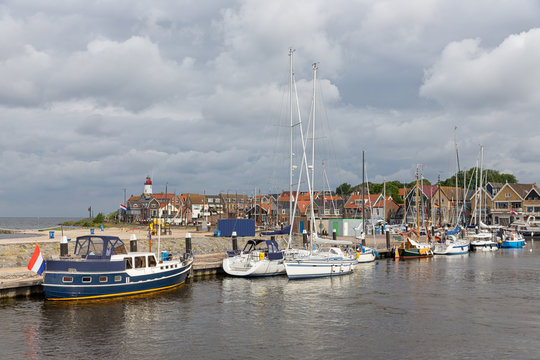 Harbor of historic Dutch village Urk with modern sailing yachts moored to a pier