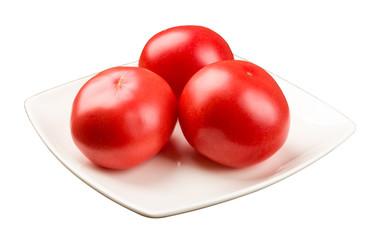 Three tomatoes on a square plate isolated on white 