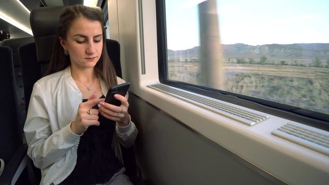 A young lady using a smartphone in the train. Medium shot.