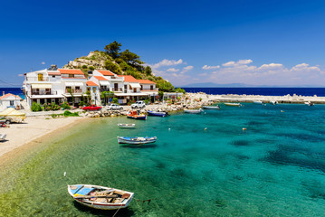 The picturesque village of Kokkari with traditional houses and fishing boats. Kokkari village is a popular tourist place on the island of Samos. - obrazy, fototapety, plakaty