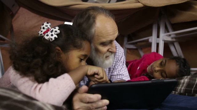 Kids teaching grandpa to use smart gadget