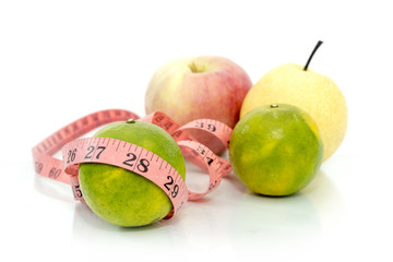 fruits with measure tape over white background