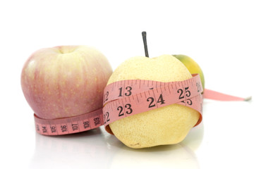 fruits with measure tape over white background