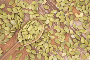 Pumpkin seeds on the wooden background