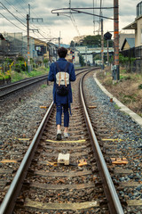 Fototapeta na wymiar A young man walks along the rails, the Japanese province