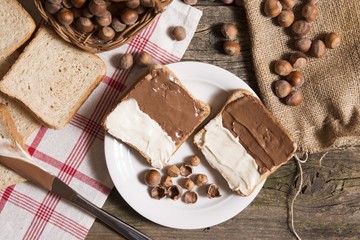 top view of bread slice with chocolate and vanilla nutella cream on wooden table