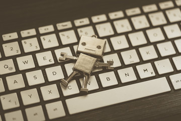 Roboter auf Tastatur, Methapher für Chatbot / Socialbot, Algorithmen und künstliche Intelligenz 