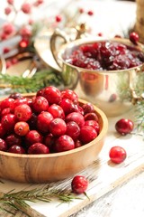 Raw Cranberries served in a wooden bowl  on white wooden background, selective focus