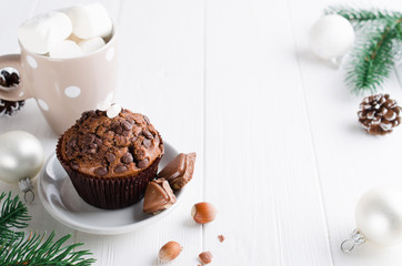 Christmas chocolate muffin on white wooden table.