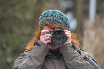 A woman photographed, the camera in focus and the motive in the visor