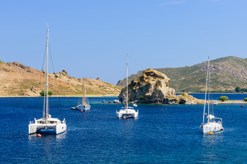 Fototapeta na wymiar A beautiful Bay with yachts. Bay of Grikos is a popular destination on the island of Patmos, Greece