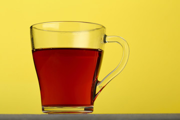 One Cup of black tea on yellow backdrop