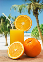 Glass of orange juice on a beach