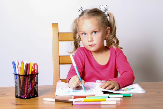 girl drawing sitting at the table