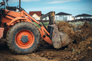 Industrial machinery at working construction site. Backhoe loader working with engineer