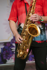Fototapeta premium Saxophone player with the saxophone in arms, playing with it.