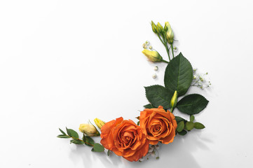 Orange roses with green addons in frame composition, isolated in white backround, top view, flat lay