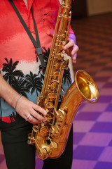 Musician playing on the saxophone at room.