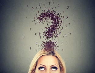 Young woman with big questions above head and no answer