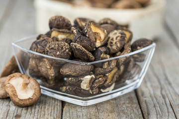 Portion of Shiitake mushrooms (dried) on wooden background, selective focus