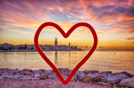Adriatic coast sunset, Porec, Croatia.
Red heart shape as a love symbol against panoramic view of Porec, during sunset with cloudy sky.