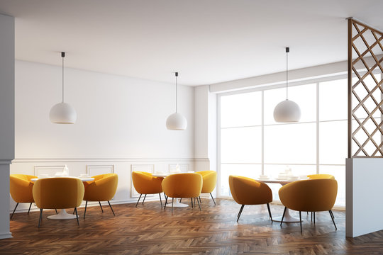 White cafe interior, orange chairs