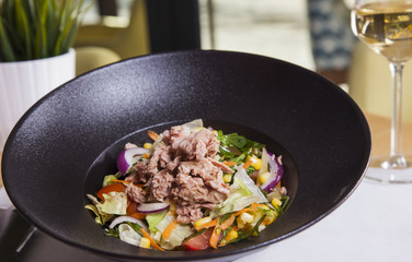 Fresh salad with tuna, tomatoes, eggs, arugula and mustard on white textured background top view. Healthy food.